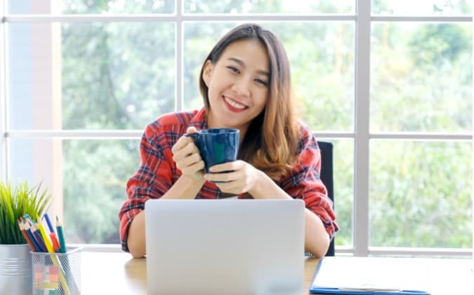 Girl Drinking Coffee In Front Of A Computer